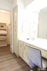 a bathroom with a sink and a mirror and a chair at Your home away from home! in Jackson