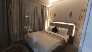 a bedroom with a bed with white sheets and pillows at Alzahaby Apartmen Sakarya CADDE54 in Serdivan