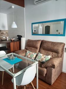 ein Wohnzimmer mit einem Sofa und einem Glastisch in der Unterkunft Apartamento Esperanza in Sevilla
