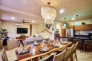 comedor y sala de estar con una gran mesa de madera en Spacious & Comfy Penthouse Oasis with Plunge Pool, en Tulum