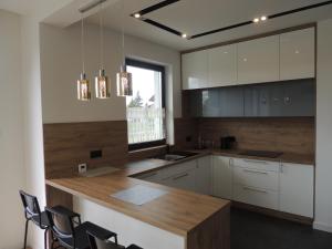 a kitchen with white cabinets and a wooden counter top at New House White near Targi Kielce in Kielce