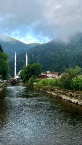 a river with two white towers in a town at ÇAVUŞ APART in Uzungol