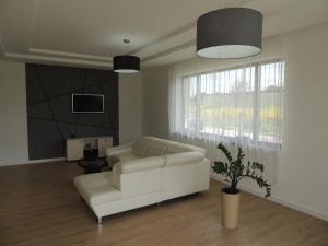 a living room with a white couch and a tv at New House White near Targi Kielce in Kielce