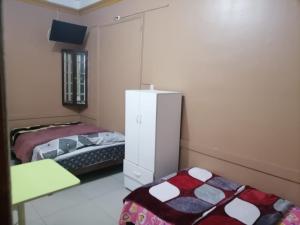 una camera con due letti e un armadietto bianco di EL SEÑORIAL a Lima
