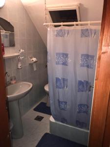 La salle de bains est pourvue d'un lavabo et d'un rideau de douche. dans l'établissement Gabi apartman, à Fonyód