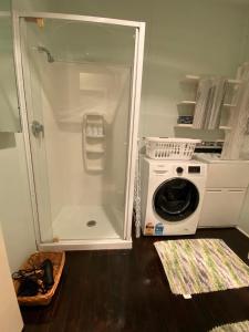 a bathroom with a washing machine and a washer at The Cozy Hutt Home in Upper Hutt