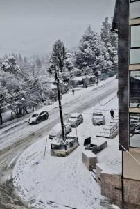 Una calle cubierta de nieve con coches aparcados en ella en El Escaramujo en San Carlos de Bariloche