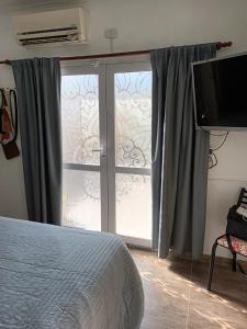 1 dormitorio con ventana y puerta corredera de cristal en Loft Avis en San Luis