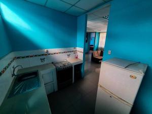 uma cozinha azul com um lavatório e um frigorífico em D301 em Moyobamba