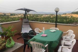 a table and chairs on a balcony with an umbrella at Al Renaio in Sarteano
