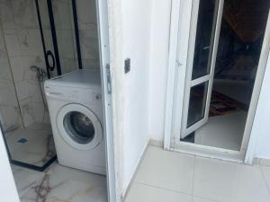 a washing machine in a bathroom next to a window at Tourist pansiyon 2 in Antalya