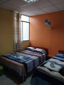 1 dormitorio con 2 camas, ventana y ventilador en D-302, en Moyobamba
