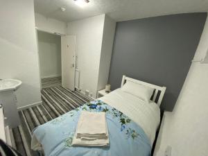 um pequeno quarto com uma cama e um lavatório em Aaran Central Guesthouse em Aberdeen