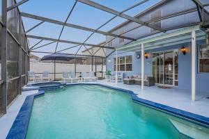 una piscina con un patio al aire libre y una casa en 5 Bedroom Villa l 12 min to Disney l Themed Rooms l Orlando Area en Davenport