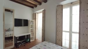 カディスにあるDormir en Cádizのベッドルーム1室(ベッド1台、壁にテレビ付)
