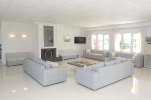 a living room with white furniture and a fireplace at Hilltop in Hanioti