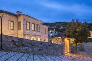 a large brick building with a stone wall at Monopatia Resort in Ano Pedina