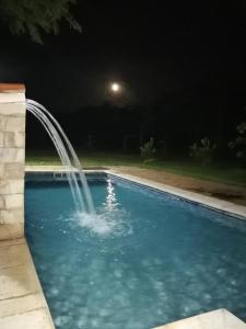 una fuente en una piscina por la noche en Posada Turística Vicenta Aguayo en Yaguarón