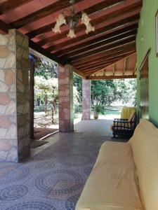 a covered porch with a bed and a couch at Posada Turística Vicenta Aguayo in Yaguarón