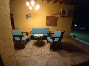 a living room with blue chairs and a table at Posada Turística Vicenta Aguayo in Yaguarón