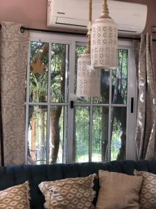 ein Wohnzimmer mit einem Sofa und einem Fenster in der Unterkunft Almagicama in Villa Serrana