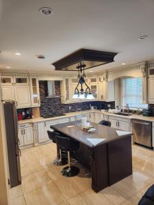 a large kitchen with a large island in the middle at Harmony Hospitality "Walking Distance to Surrey Central" in Surrey