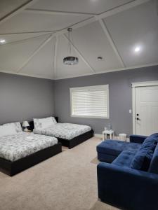 1 dormitorio con 2 camas y sofá azul en Harmony Hospitality "Walking Distance to Surrey Central", en Surrey