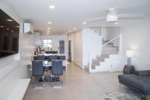 a living room with a staircase and a table and chairs at 232C South Finger in Jolly Harbour