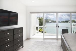 a bedroom with a large window with a view of the water at 232C South Finger in Jolly Harbour