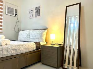 a bedroom with a bed and a large mirror at Olvera Residences- Mandalagan Bacolod in Bacolod
