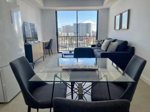 a living room with a glass table and chairs at Cosy Stays 1 Bedroom Apartment Rosebery Parking & Balcony Sydney Escape in Sydney