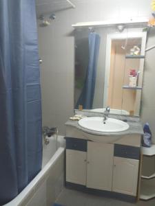 uma casa de banho com um lavatório, um espelho e uma banheira em Carlos y Fernanda em Madri
