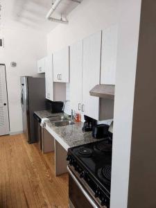 a kitchen with white cabinets and a stove top oven at The Best Spot in Downtown St. Louis!! in Saint Louis