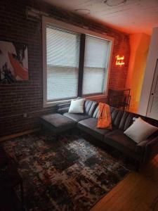 a living room with a couch and a brick wall at The Best Spot in Downtown St. Louis!! in Saint Louis