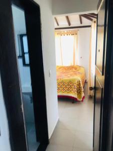 een slaapkamer met een bed in een kamer met een raam bij el recuerdo in Villa de Leyva