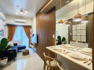 een keuken en een woonkamer met een tafel en stoelen bij Happirest at Coast Residences, Pasay - 1 Bedroom with Balcony in Manilla