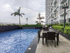 a dining area with a table and chairs next to a building at Happirest at Coast Residences, Pasay - 1 Bedroom with Balcony in Manila