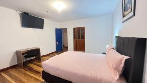 sypialnia z łóżkiem, biurkiem i telewizorem w obiekcie Valicha Casa Hotel w Cuzco