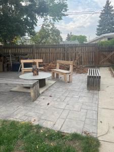 un patio con bancos, una mesa y una valla en Spacious Room & Living Area in NW! en Calgary