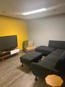 sala de estar con sofá y TV de pantalla plana en Spacious Room & Living Area in NW! en Calgary