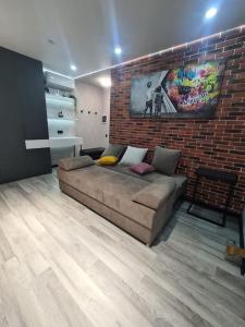 a living room with a couch and a brick wall at CityView Apartment in Chişinău