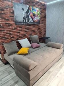 a couch in a room with a brick wall at CityView Apartment in Chişinău