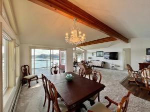una sala da pranzo con tavolo, sedie e lampadario pendente di The Captains View - Cliffside, Ocean Views a Kodiak