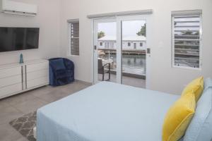 a bedroom with a bed and a tv and a window at 246D South Finger in Jolly Harbour