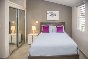 a bedroom with a large bed with pink pillows at 246D South Finger in Jolly Harbour