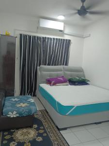 ein Schlafzimmer mit einem Bett und einem Stuhl in der Unterkunft Homestay Danau Ria @ Gamuda Gardens in Pengkalan Kundang