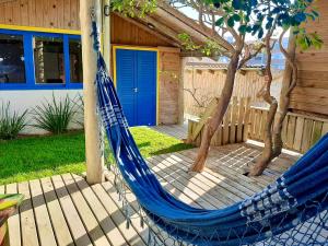 a blue hammock in front of a house at Pousada Villa Del Mar in Farol de Santa Marta