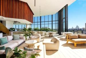 a large lobby with couches and tables and windows at Casino Residences 1 & 2 Bedroom Apartment in Gold Coast