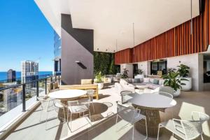 Cet appartement dispose d'un balcon avec des tables et des chaises. dans l'établissement Casino Residences 1 & 2 Bedroom Apartment, à Gold Coast