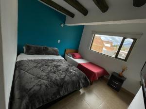 a bedroom with a bed and a window at Hotel Verona Villa de Leyva in Villa de Leyva